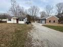 Exterior view of the home and detached garage, showcasing the lot and curb appeal of the property at 13421 Miller Dr, Camby, IN 46113