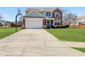 Charming two-story home with a brick and siding exterior, complemented by a well-manicured lawn and long driveway at 14126 Secretariat Ct, Carmel, IN 46074