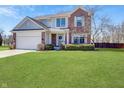 Charming two-story home with a brick and siding exterior, complemented by a well-manicured lawn and landscaping at 14126 Secretariat Ct, Carmel, IN 46074