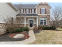 The home's inviting entrance is framed by elegant stone accents, offering a warm welcome to visitors at 14466 Integrity Ct, Carmel, IN 46033