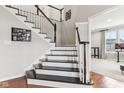 Bright, traditionally styled staircase with dark wood treads and white risers and banisters at 14466 Integrity Ct, Carmel, IN 46033