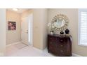 Inviting entryway with decorative mirror, stylish chest, tiled flooring, and a view of the staircase at 1457 Dominion Dr, Zionsville, IN 46077