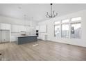 Bright kitchen featuring white cabinets, gray island, modern lighting, and hardwood flooring at 17364 Pinellas Ave, Westfield, IN 46074