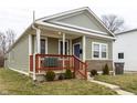 Inviting home with a covered porch, a blue front door, and charming curb appeal at 1820 E Maryland St, Indianapolis, IN 46201