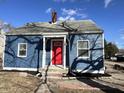 A charming blue home accented by a vibrant red door, creating a welcoming entrance at 2001 Glenridge Dr, Indianapolis, IN 46218
