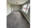 Bright living room with large windows and neutral carpet at 2032 Costello Dr, Anderson, IN 46011