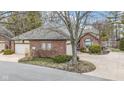 Brick single-story home features an attached two-car garage, landscaped front yard and curving driveway at 2042 Oldfields Cir N Dr, Indianapolis, IN 46228