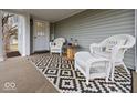 Inviting front porch featuring comfortable wicker seating and stylish outdoor rug at 208 S Conger St, , IN 47272