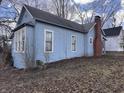Side view of a light blue home showcasing its classic architecture and chimney at 2933 E 56Th St, Indianapolis, IN 46220
