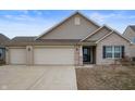 Attractive single-Gathering home with a three-car garage, brick details, neutral siding, and a freshly sealed concrete driveway at 3328 Stoddard Pl, Indianapolis, IN 46217
