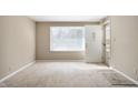 Bright, carpeted living room with large window and neutral walls at 3626 St. Charles St, Anderson, IN 46013
