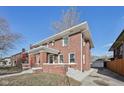Beautiful exterior elevation of this brick home with a manicured lawn, bright windows, and paved driveway at 3645 N Delaware St, Indianapolis, IN 46205