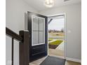 Welcoming entryway featuring a stylish front door, modern light fixture, and sleek staircase at 4261 Barrel Ln, Westfield, IN 46062