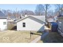 Backyard view of the house with vinyl siding, a sidewalk and green grass at 4619 Carrollton Ave, Indianapolis, IN 46205