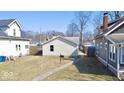 Backyard view of the house with vinyl siding, a sidewalk and green grass at 4619 Carrollton Ave, Indianapolis, IN 46205