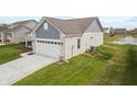 A view of the home's garage, a pond, and green space at 602 Tuscany Trl, Lapel, IN 46051