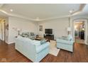Bright living room with tray ceiling, recessed lighting, hardwood floors, and plush sofas at 6400 Woodland Ln, McCordsville, IN 46055