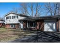 Charming split-level home featuring a brick and vinyl exterior with attached garage and extended driveway at 6616 W 15Th St, Indianapolis, IN 46214