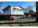 Charming split-level home featuring a brick and vinyl exterior, contrasted by a well-manicured lawn at 6616 W 15Th St, Indianapolis, IN 46214