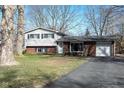 Charming split-level home featuring a brick and vinyl exterior with attached garage and driveway at 6616 W 15Th St, Indianapolis, IN 46214