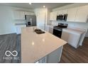 Bright kitchen with white cabinetry, stainless steel appliances, and a functional center island with a sink at 6635 Sulgrove Pl, Indianapolis, IN 46221