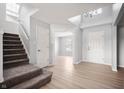 Bright foyer with wood floors, staircase, chandelier, skylight, and views into adjacent room at 6677 W Longview Dr, McCordsville, IN 46055
