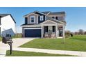 Two-story home with blue and gray siding, large garage, and front lawn at 6919 Sable Point Dr, Brownsburg, IN 46112