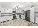 Kitchen features tile flooring, white cabinets, modern lighting, and stainless steel appliances at 714 School St, Greenfield, IN 46140