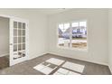 Bright bedroom with plush carpet, a large window, and stylish French doors at 7168 Jackson Dr, Cumberland, IN 46229