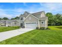 Beautiful home showcasing a well-maintained lawn, attached two-car garage and blue skies at 7168 Jackson Dr, Cumberland, IN 46229