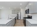 Contemporary kitchen features stainless steel appliances, gray cabinets, and a large island at 7324 Shroyer Way, Noblesville, IN 46062