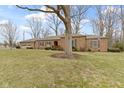 Sprawling ranch home with mature trees, brick facade and attached garage at 7481 Holliday E Dr, Indianapolis, IN 46260