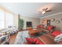 Inviting living room features hardwood floors, neutral walls, brown leather sofas and a ceiling fan at 839 N Park Trail Dr, Carmel, IN 46032
