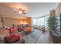 Cozy living room with hardwood floors, leather sofa, ceiling fan, and plenty of natural light at 839 N Park Trail Dr, Carmel, IN 46032