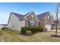 An appealing side view shows the home's brick and vinyl siding, with a green lawn at 8708 N Deer Crossing Blvd, McCordsville, IN 46055