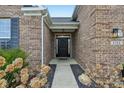 A beautiful covered entryway features a black front door and manicured landscaping at 8708 N Deer Crossing Blvd, McCordsville, IN 46055