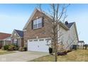The home's garage and side are prominent, showing the brick and vinyl siding, and lawn at 8708 N Deer Crossing Blvd, McCordsville, IN 46055