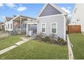 Alluring home with tidy landscaping, gabled roof, covered porch, and freshly painted gray siding at 1210 S State Ave, Indianapolis, IN 46203
