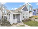 Charming gray home with a cozy covered porch, gabled roof, well-kept lawn, and freshly painted siding at 1210 S State Ave, Indianapolis, IN 46203
