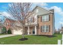 Two-story home with brick accents, a well-manicured lawn, and a charming tree in the front yard at 12777 Rotterdam Rd, Fishers, IN 46037