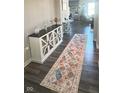 Inviting entryway with hardwood floors, decorative cabinet and console table, and a colorful patterned rug at 15408 Brown Jack Dr, Fishers, IN 46040