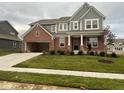 Two-story home with a brick facade, attached two-car garage, concrete driveway, and a well-maintained lawn at 15408 Brown Jack Dr, Fishers, IN 46040