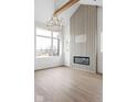 Bright, open living room with hardwood floors, fireplace with accent wall, and a modern chandelier at 1668 Carrollton Rail Dr, Westfield, IN 46074