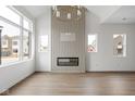 Bright living room with a modern fireplace, wood accent wall, and light hardwood floors at 1668 Carrollton Rail Dr, Westfield, IN 46074