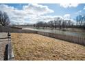Expansive backyard with a wooden fence overlooking a serene river at 1841 Sonesta Ln, Indianapolis, IN 46217