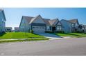 Inviting single-story home featuring a covered entryway, green lawn, and grey two-car garage at 2349 S Copperstone Dr, New Palestine, IN 46163