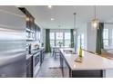 Modern kitchen featuring stainless steel appliances, center island, and a view into the dining area at 275 Hunters Ridge Dr, Danville, IN 46122