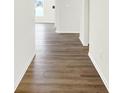 A light and airy hallway shows clean white walls and attractive wood laminate flooring at 3687 Thomas Jefferson Ct, Westfield, IN 46074