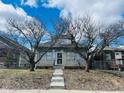 Modest single-story home featuring a stone facade, metal security door, and mature trees in front of the property at 428 N Alton Ave, Indianapolis, IN 46222