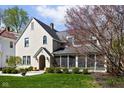 Attractive home exterior with a screened porch, lush lawn, and mature tree providing shade and curb appeal at 4310 Central Ave, Indianapolis, IN 46205